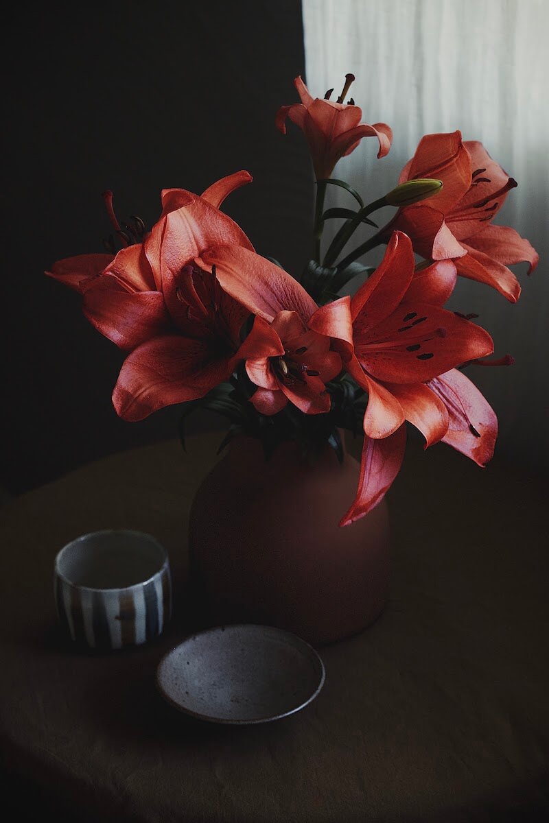 Red lillies arragement in a dark room
